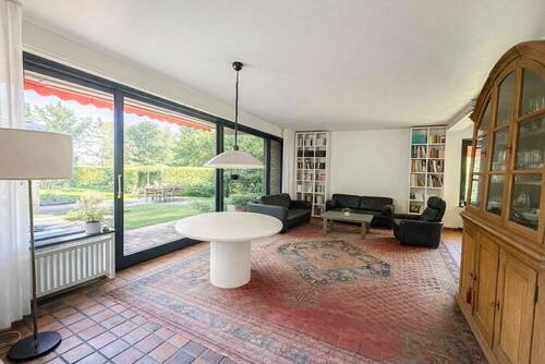 Wohnzimmer mit heller Fensterfront zum Garten - 