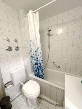 Hell gefliestes Bad mit Badewanne - 