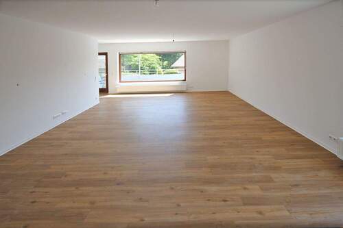 Wohnzimmer mit Fensterfront zum Balkon - 