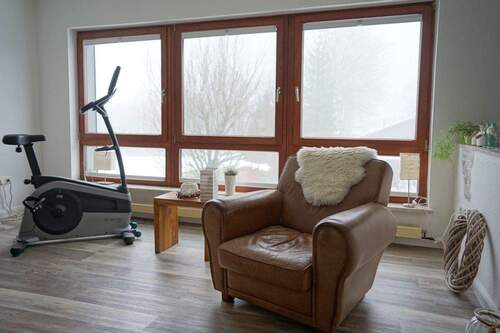 Relax-Bereich mit Panoramafenster und Blick in den Garten - 