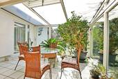 Gemütlicher Wintergarten mit Blick in den Garten - 