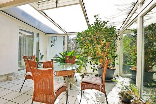 Gemütlicher Wintergarten mit Blick in den Garten - 