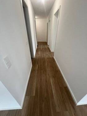 Langer Flur mit Holzboden - 