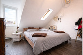 Gemütliches Dachgeschoss-Schlafzimmer bei Tageslicht - 