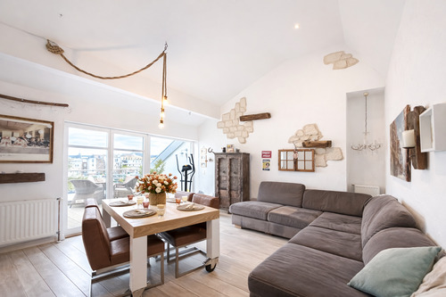 Helles Wohnzimmer mit blühendem Esstisch - 