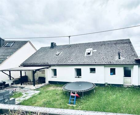Rückseite mit überdachter Terrasse und Spielfläche - 