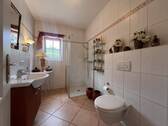 Modernes Badezimmer mit begehbarer Dusche und praktischen Stauraum-Lösungen - 