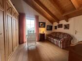 Schlafzimmer mit Holzbalkendecke und direktem Balkonzugang - 