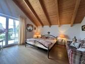 Helles Schlafzimmer mit charaktervoller Holzbalkendecke und Terrassenzugang - 