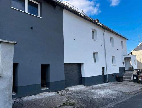 neu renovierte Fassade mit integrierten Garagen - 