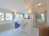 Hell gefliestes Tageslichtbadezimmer mit Doppelwaschbecken, WC-Nische, Badewanne und Dusche - 