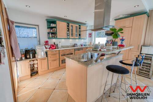 Küchenbereich mit Kochinsel und Theke im Erdgeschoss - 