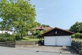 Straßenansicht mit Doppelgarage und Stellplätzen - 