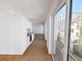 Ansicht I: Wohn- und Esszimmer mit offenem Küchenbereich - Genießen Sie den Sommer auf Ihrem Balkon in Ihrer 2-Zimmer-Neubauwohnung!