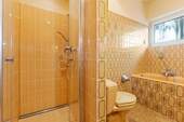 Badezimmer mit Dusche, Badewanne und Fenster - 
