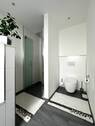 Badezimmer mit Blick auf Dusche und WC - 