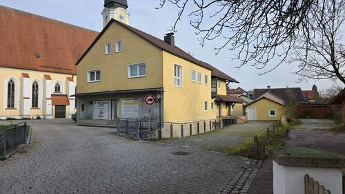 Außenbereich mit Eingangsbereich zur Gewerbefläche und die Schaufenster - Mehrfamilienhaus, Wohnhaus mit 165,00 m&sup2; in Tettenweis zum Kaufen