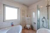 Badezimmer mit Badewanne und Dusche - 