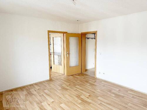 Wohnzimmer mit Blick Richtung Flurbereich und Küche - 