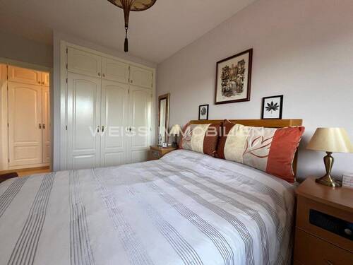 Schlafzimmer mit Einbauschrank und großen Fenstern - 