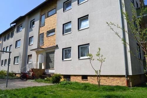 Birkenallee 99: Außenansicht auf den Eingangsbereich eines Mehrfamilienhauses in Riegelbebauung (drei Gebäude) mit Satteldach. - 3 Zimmer Etagenwohnung zur Miete in Baunatal