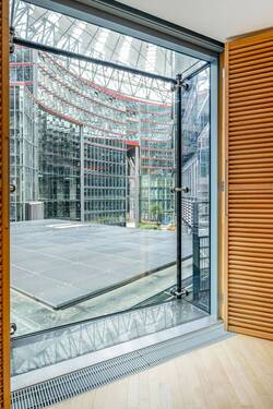Bodentiefe Fenster und Austritt mit Blick in das Center am Potsdamer Platz - Zwischen High-Tech und Tiergarten: Wohnen in der Esplanade Residence