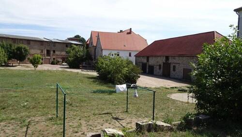 Hoffläche mit Scheunen u. Gutshaus im Hintergrund - 