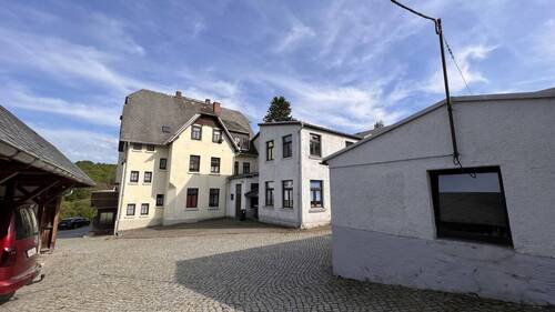 Blick auf das Wohnhaus mit Gewerbeanbau aus Richtung Garten - 