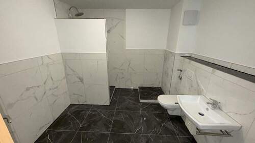 Bad mit Waschmaschinenpodest - Neu renovierte 2,5-Zimmer-Wohnung mit Küche, Dachterrasse, Abstellkammer & TG-Stellplatz