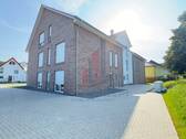 Eine Seitenansicht des neu gebauten Mehrfamilienhauses - 