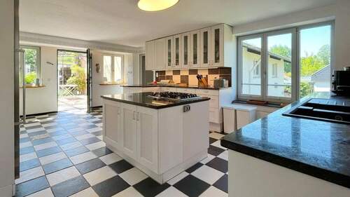 Die zeitlose Küche bietet viel Stauraum und ist mit Gas- und Elektroherd ausgestattet - 