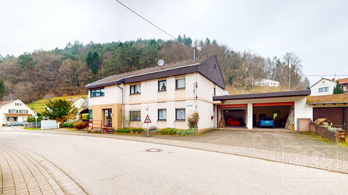 Haus Vorderseite mit großen Garagen und Stellplätzen - 