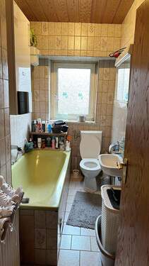 Badezimmer mit Badewanne und Fenster - 