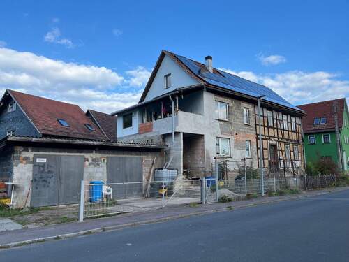 Ansicht seitlich mit Balkon und Garage - Einfamilienhaus mit idyllischer Scheune und geräumiger Doppelgarage in schönem Ambiente