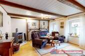 Wohnzimmer mit sichtbaren Holzbalken und Kaminofen – der gemütliche Mittelpunkt des Hauses - Einfamilienhaus mit 120,00 m&sup2; in Etgersleben zum Kaufen