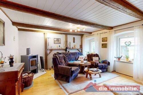 Wohnzimmer mit sichtbaren Holzbalken und Kaminofen – der gemütliche Mittelpunkt des Hauses - Einfamilienhaus mit 120,00 m&sup2; in Etgersleben zum Kaufen