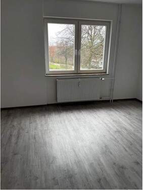 Schlafzimmer mit Blick zum Fenster, helle Wände und hellgrauer Bodenbelag in Holzoptik.JPG - 