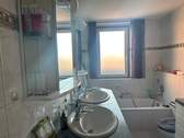 Badezimmer mit Badewanne und Fenster - 