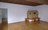Wohnzimmer mit historischer Decke und Kachelofen im Erdgeschoss - 