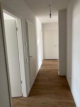 Flur mit weißen Wänden und braunen Vinyl-Designboden in Holzoptik - 