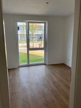 Schlafzimmer mit weißen Wänden, brauner Vinyl-Designboden in Holzoptik - 