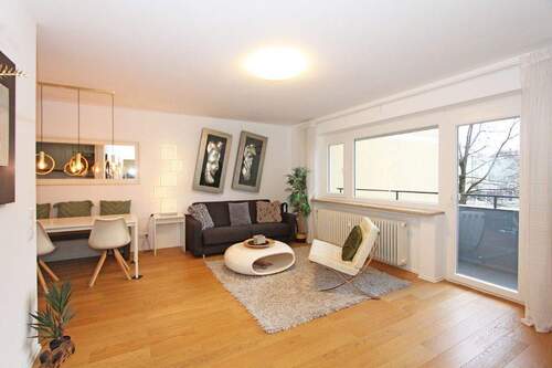 Großzügiger Wohnbereich mit Zugang zum Balkon sowie der offenen Einbauküche - 4 Zimmer Etagenwohnung in München