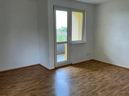 Wohnzimmer mit Zugang zum Balkon und hochwertigem PVC-Bodenbelag in Holzoptik - 4 Zimmer Etagenwohnung zur Miete in Bad Vilbel