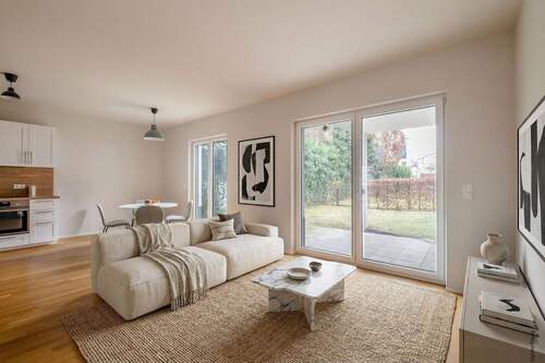 Blick vom Wohnbereich zur Küche und Terrasse - Schöne 3-Zimmer-Neubauwohnung mit Terrasse und zwei Privatgärten