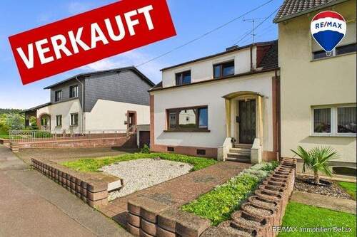 RE/MAX Immobilien DeLux Einfamilienhaus Nalbach Frontansicht - Charmantes Einfamilienhaus mit großem Garten und Waldblick - Sanierungsobjekt mit Potenzial!