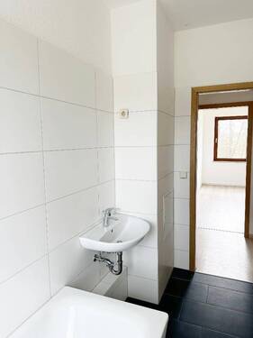 Tageslichtbad mit Wanne, WC und Waschtisch und Blick Richtung Flurbereich - 