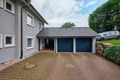 Objektansicht mit Garagen und Carport - 