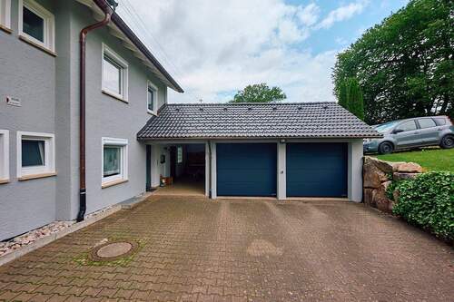 Objektansicht mit Garagen und Carport - 