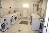 Komfortable Waschküche mit modernen Geräten und praktischer Infrastruktur - 
