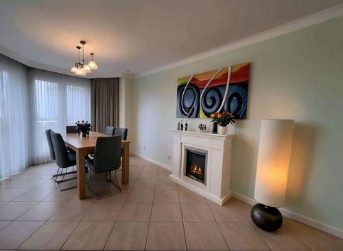 Gemütlicher Wohn-Essbereich mit elegantem Kamin und lichtdurchfluteter Atmosphäre - 